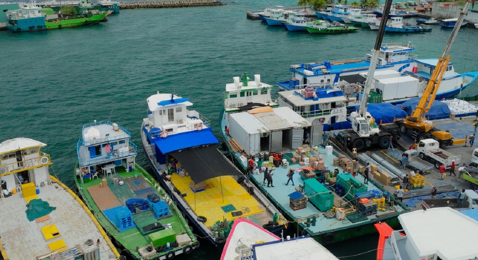 Supply dhonis loading cargo for resort delivery at a Malé harbour jetty